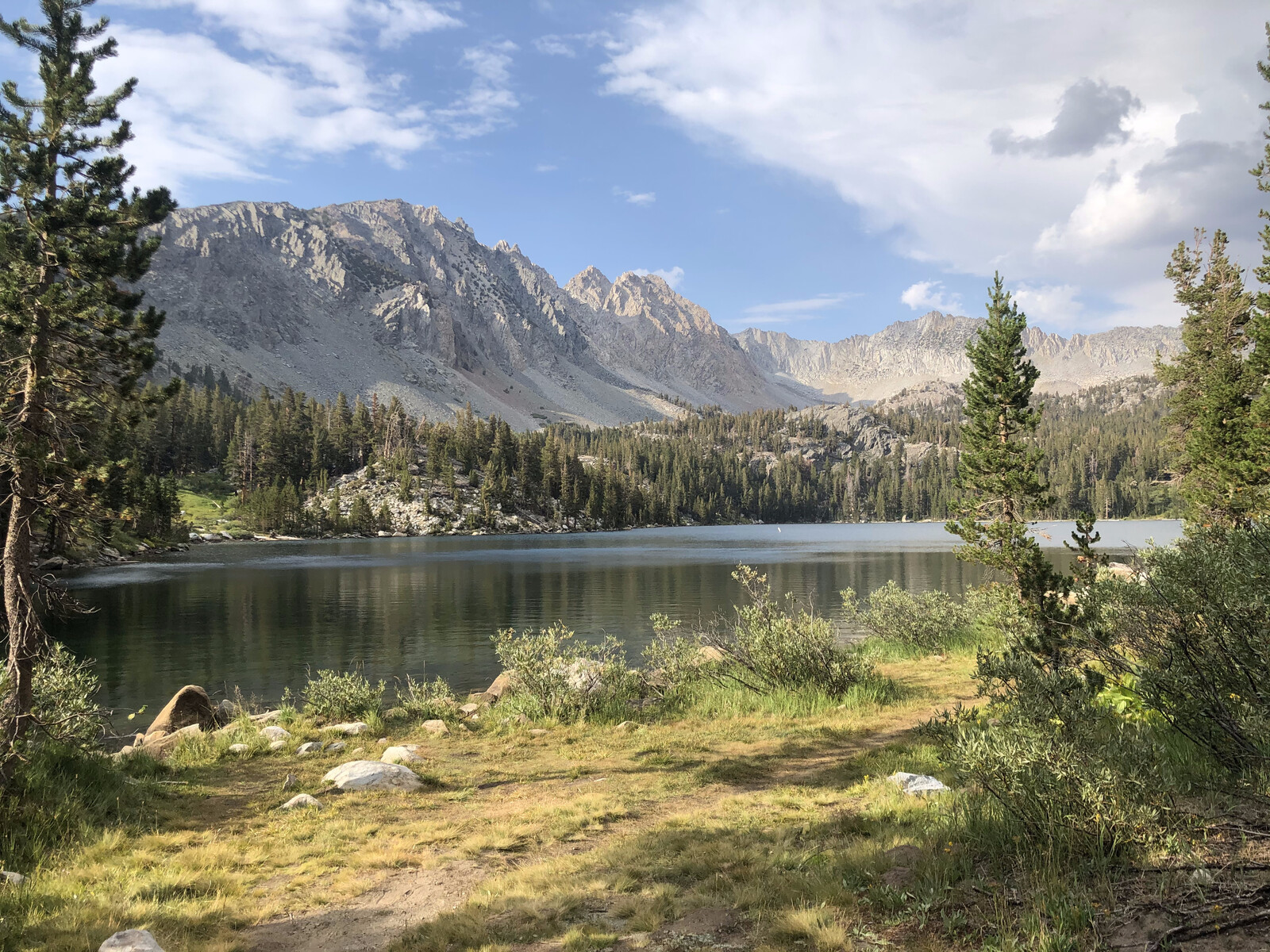 Mirror-like alpine lake reflecting mountain peaks perfectly