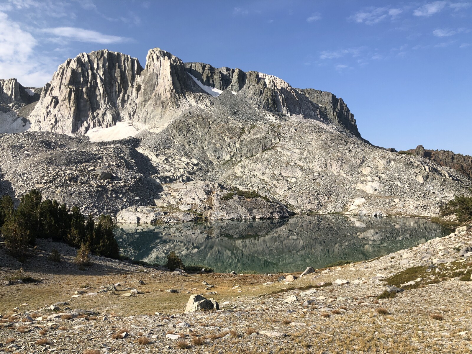 Granite dome peaks reflected in calm alpine lake