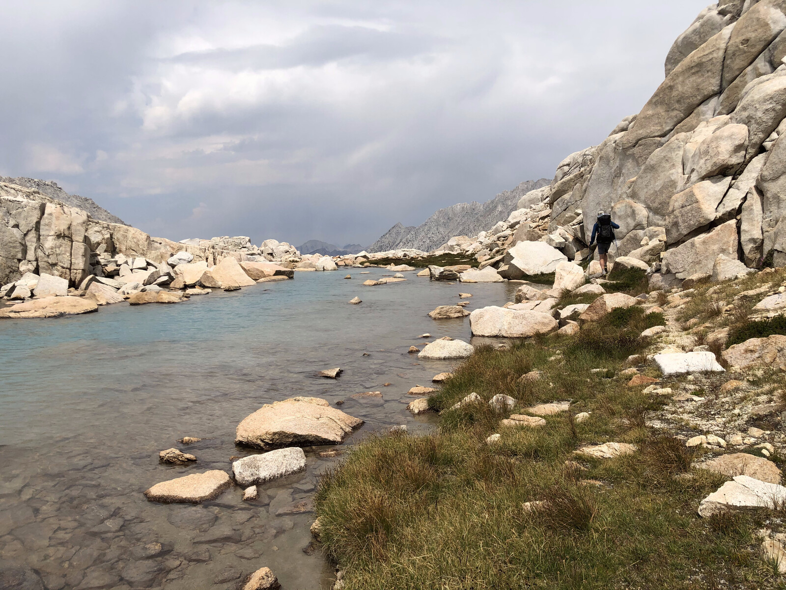 Turquoise alpine lake surrounded by tall granite cliffs