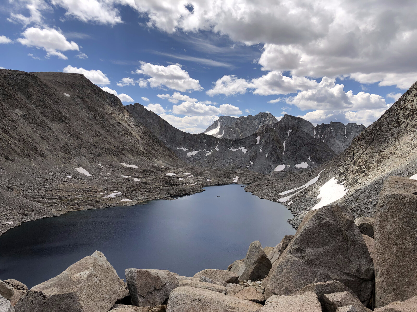 Deep blue alpine lake reflecting jagged mountain peaks